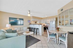 a living room and kitchen with a couch and a table at Summer Breeze #25 - Modest Beachfront with views of the Pass! Great Location! in Orange Beach