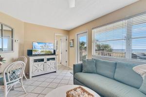 a living room with a blue couch and a television at Summer Breeze #25 - Modest Beachfront with views of the Pass! Great Location! in Orange Beach