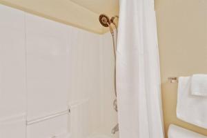 une salle de bain avec une douche avec un rideau de douche blanc dans l'établissement Summer Breeze #25 - Modest Beachfront with views of the Pass! Great Location!, à Orange Beach 12 autres photos