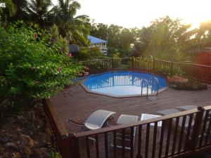 a deck with chairs and a swimming pool at Le matelot de la baie in Deshaies
