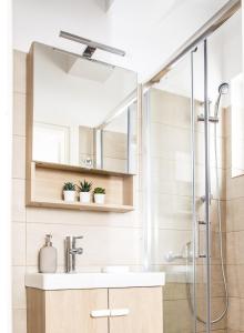 y baño con lavabo y ducha. en Boho Blu by A&D Properties, en Porto Rafti
