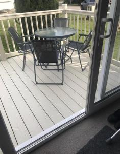 a patio with a table and chairs on a deck at private rented caravan situated at Southview holiday park in Winthorpe