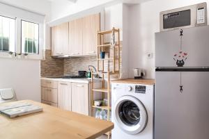 a kitchen with a washer and dryer in it at Boho Blu by A&D Properties in Porto Rafti