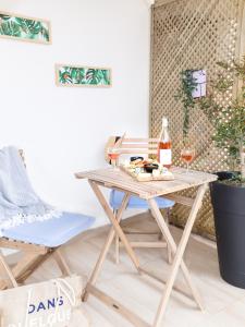 una mesa de picnic y sillas en la sala de estar con una botella de vino en Boho Blu by A&D Properties, en Porto Rafti