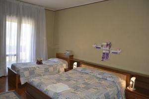 a bedroom with two beds and a cross on the wall at Bed & Bike Belfiore in Montagnana