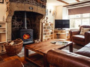 a living room with a stone fireplace and a table at Bastle House in Haltwhistle