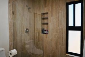 a bathroom with a shower with a glass door at Flor de Garambullo, Valle de Guadalupe in Valle de Guadalupe +24 photos