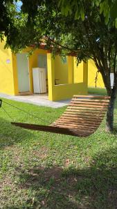 a hammock in the grass in front of a building at Pousada Chalés Praia Vermelha in São João Batista do Glória