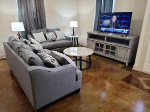 a living room with a couch and a flat screen tv at Villa 5 in Hammond