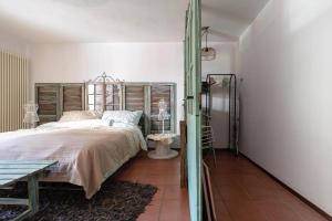 Schlafzimmer mit einem großen Bett mit einem Kopfteil aus Holz in der Unterkunft La Maison de Coco in Muzzano