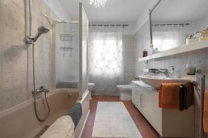 a bathroom with a tub and a sink and a shower at La Maison de Coco in Muzzano