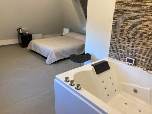 un bagno con vasca e un letto in una camera di Wellness Suite Utrecht a Utrecht