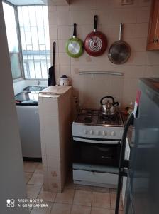 a kitchen with a stove and some pots and pans at Depto Metro Irarrazaval Santiago in Santiago