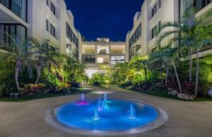 une grande piscine bleue en face d'un bâtiment dans l'établissement Departamento 2 recámaras Anah, à Playa del Carmen