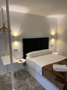 a bedroom with a large bed and a desk at Hostal Alaska in Madrid
