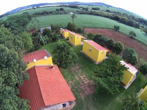 an overhead view of a group of houses in a field at Pousada Chalés Praia Vermelha in São João Batista do Glória