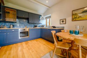 アンブルサイドにあるShepherd's Cottageのキッチン(青いキャビネット、木製テーブル付)