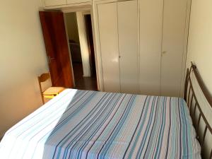 una camera con letto a righe blu e bianche di Apart 1 Dorm Sala 3 Ambientes ad Águas de Lindóia