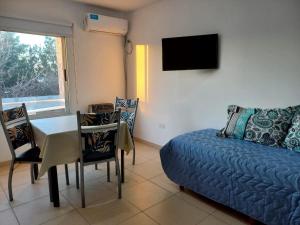 a living room with a couch and a table and a tv at El Depto de Roberto in Villa María