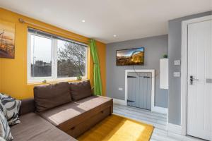 a living room with a couch and a window at Stockton town centre studio apartments free parking and Wi-Fi in Stockton-on-Tees