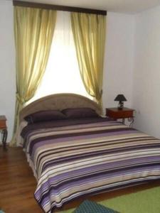 a bedroom with a large bed with a window at Guest House del Mare in Dobra Voda