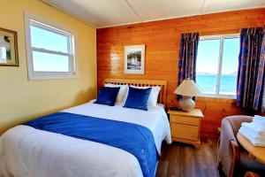 a bedroom with a blue and white bed and a window at Glenghorm Beach Resort in Ingonish +158 photos