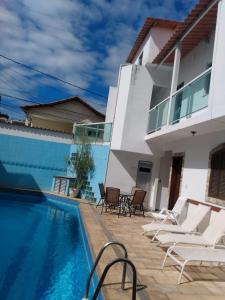 une villa avec une piscine et une maison dans l'établissement Cabo Frio Suíte com cozinha, à Cabo Frio