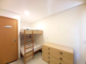 um quarto com um beliche e uma cómoda em madeira em Apartamento família com 3 quartos no Eco Resort Carneiros em Tamandaré