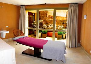 a bedroom with a bed and a window at Artesa Suites & Spa in Santo Tomé del Puerto