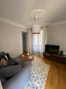 een woonkamer met een bank en een tv bij Elegant appartement Trocadéro in Parijs