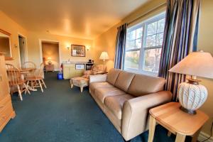 a living room with a couch and a table with a lamp at Glenghorm Beach Resort in Ingonish