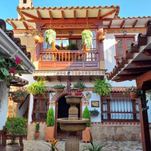 - un bâtiment avec une fontaine en face d'un balcon dans l'établissement Hostal La Casita de Toñito, à Villa de Leyva