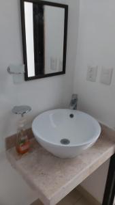 a white sink on a counter in a bathroom at Beach Castell Suites in Playa del Carmen