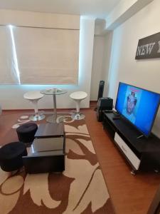 a living room with a television and a table and chairs at DEPARTAMENTO ESTUDIO FULL EQUIPADO WIFI CERCA A TODO LIMA in Lima