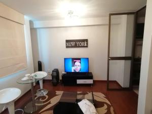 a living room with a tv and a table at DEPARTAMENTO ESTUDIO FULL EQUIPADO WIFI CERCA A TODO LIMA in Lima