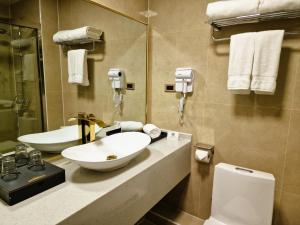 uma casa de banho com um lavatório e um WC em New West Hotel em Ulan Bator