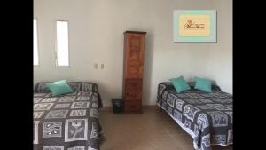 a bedroom with two beds and a dresser at Casa María Bonita in Pérula