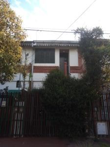 a white house with a gate and a fence at La Escalerita- Estadio Kempes in Córdoba