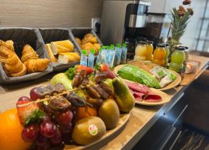 un buffet con molti tipi di cibo e bevande di Leclerc Hotel Centre Gare a Le Mans