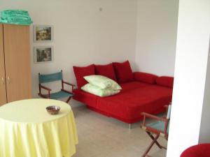 a living room with a red couch and a table at 6 Treti Mart street 2 floor in Primorsko