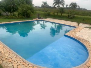 a large swimming pool with blue water in a yard at Muiraquitã Hotel in Ourilândia do Norte +11 photos