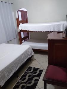 Zimmer mit 2 Betten, einer Kommode und einem Teppich in der Unterkunft Cabo Frio Suíte com cozinha in Cabo Frio