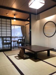 uma sala de estar com uma mesa e um espelho em Kajiyabekkan Ramakkoro Yamaneko Yado em Ichinoseki