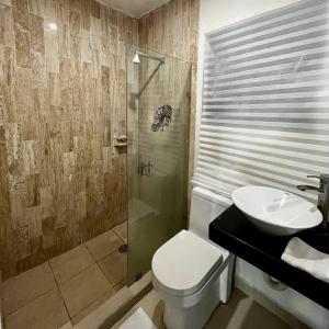 a bathroom with a toilet and a sink and a shower at Condominio en ZH Cancun in Cancún