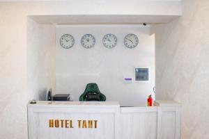 um quarto com relógios na parede e uma tenda de hotel em Hotel Taht em Tashkent