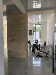 ein Wohnzimmer mit einer Steinmauer und einem Tisch in der Unterkunft Villa privada en condominio San Simon in Carmen de Apicalá