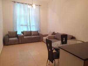 a living room with a couch and a table at Lovely 1-bedroom Apartment with free Parking on premises in Ajman 