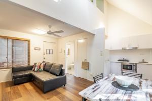 a living room with a couch and a table at Byron Central Apartments in Byron Bay