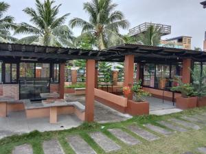a pavilion with benches and palm trees in front of a building at RedDoorz at Solid Rock Guest House Dipaculao Aurora in Dipaculao