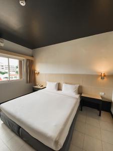 1 cama blanca grande en una habitación con ventana en Garden View Betong Hotel, en Betong